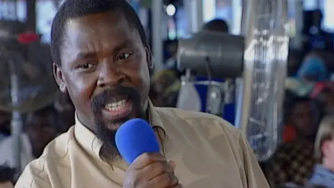 Journeyman Pictures TB Joshua holding a blue microphone